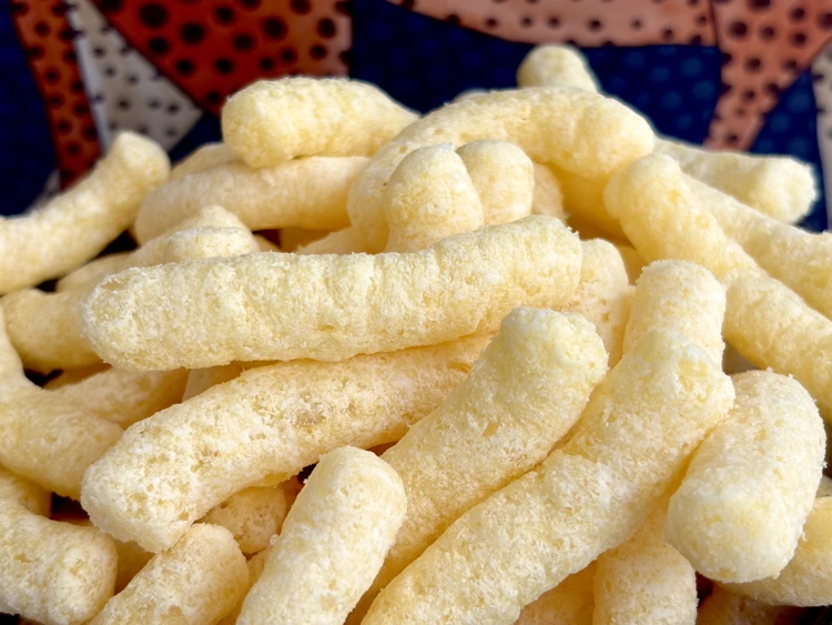 A close up of Cheetos Simply Puffs with leopards in the background